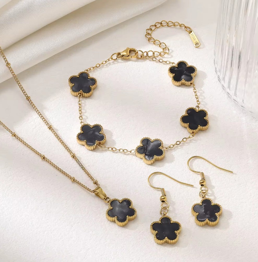 Aurelia Designs 3-piece jewellery set featuring black shell clover charms on 18k gold-plated stainless steel chains.
