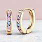 Aurelia Designs 18K gold-plated huggie earrings featuring pink, lilac, and blue cubic zirconia stones.